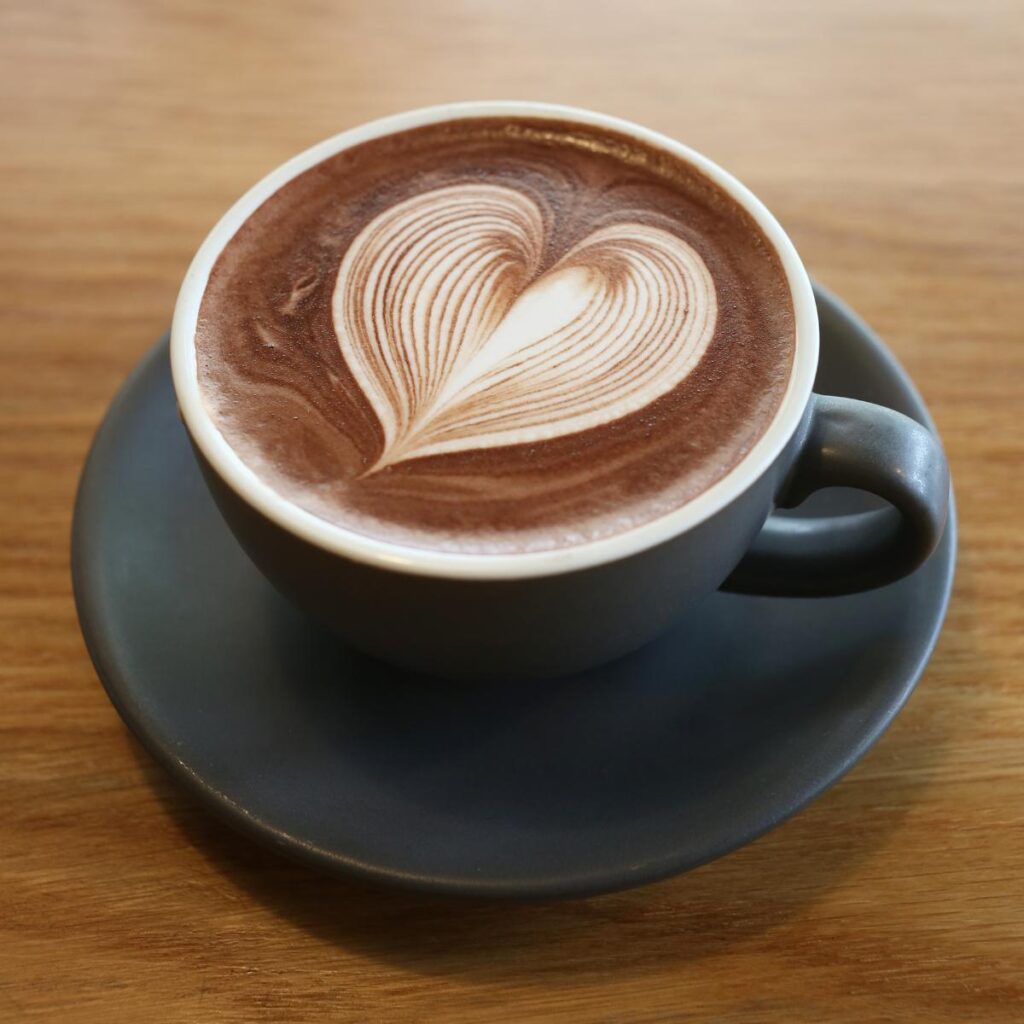 A cup of coffee with heart form art on top.